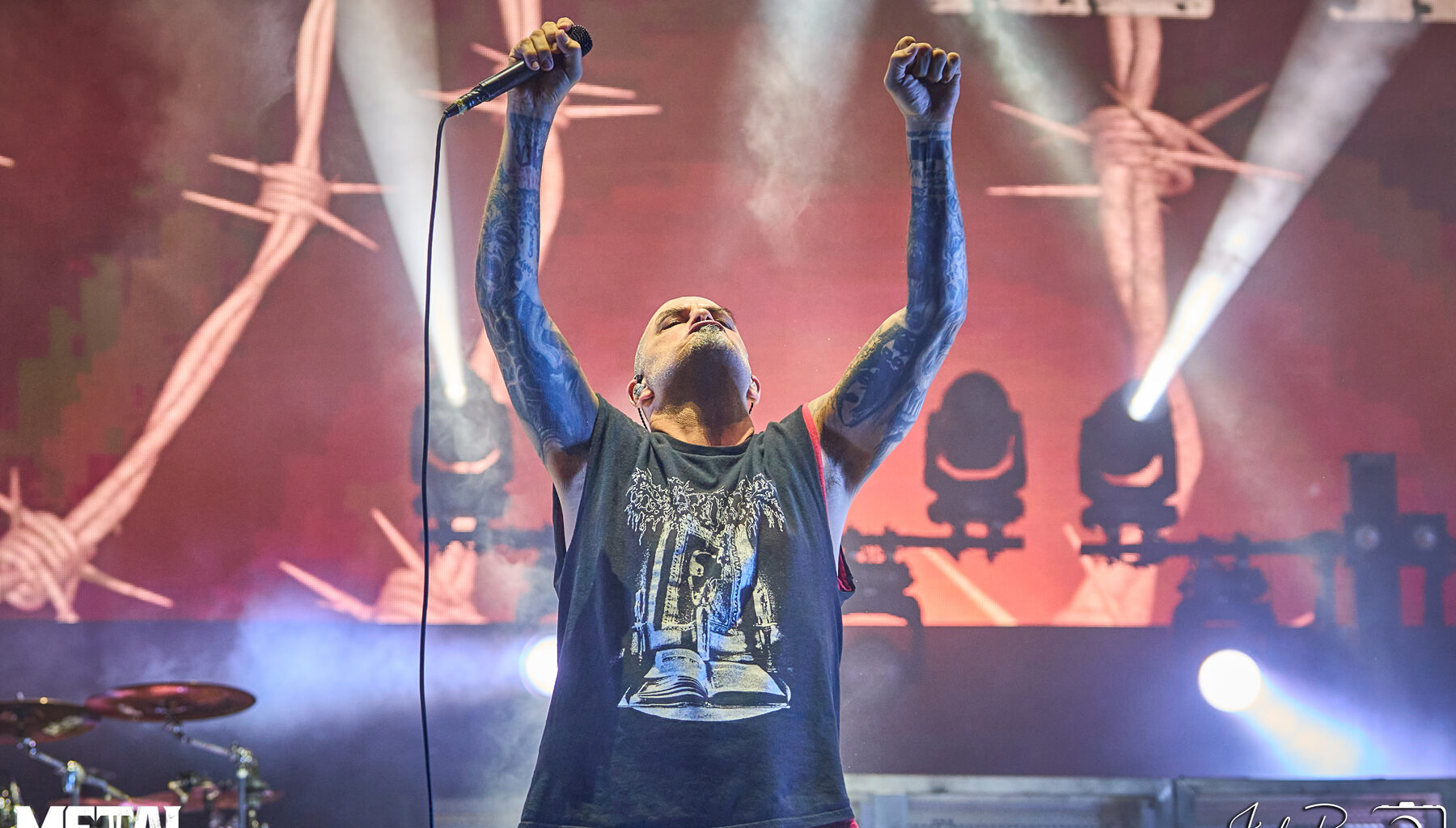 Phil Anselmo, lead vocalist of Pantera, performing live on stage with intense energy and iconic microphone stance