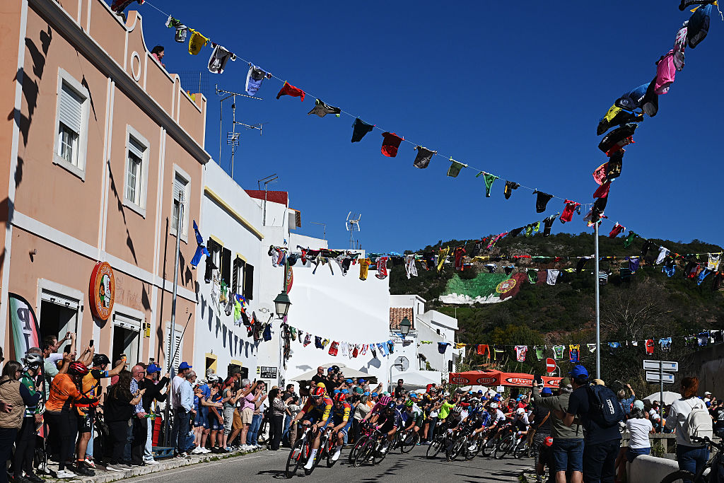 LOULE, PORTUGAL - FEBRUARY 22: A general view of the peloton passing through a landscape while fans cheers during the 52nd Volta ao Algarve em Bicicleta 2026, Stage 5 a 148.4km stage from Faro to Malhao - Loule 512m on February 22, 2026 in Loule, Portugal. (Photo by Dario Belingheri/Getty Images)