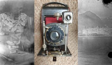 A vintage folding camera with a black and gold lens sits on a tan surface. Faded black-and-white photos border the image, showing a person on the left and a lakeside building and mountains on the right.