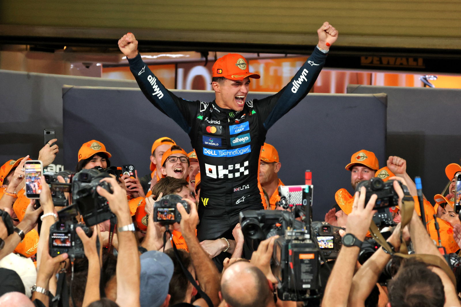 Lando Norris celebrates with his McLaren team after winning the Formula 1 drivers' championship.