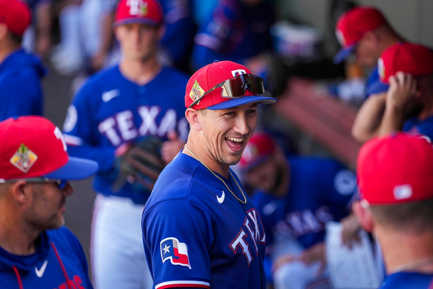 Texas Rangers outfielder Wyatt Langford laughs in the dugout before a spring training game...