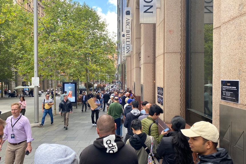 A long line of people on a street in one of Sydney's business districts.