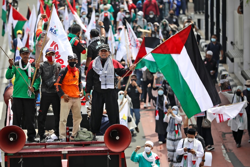 Crowds march down the street as part of a pro-Palestinian rally in Jakarta