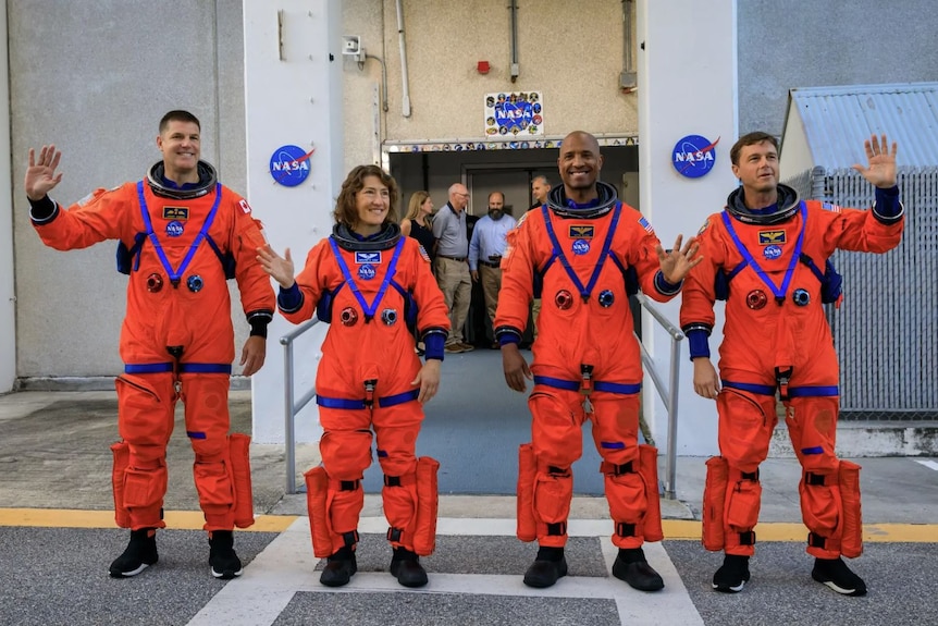 Four people in orange space suits.