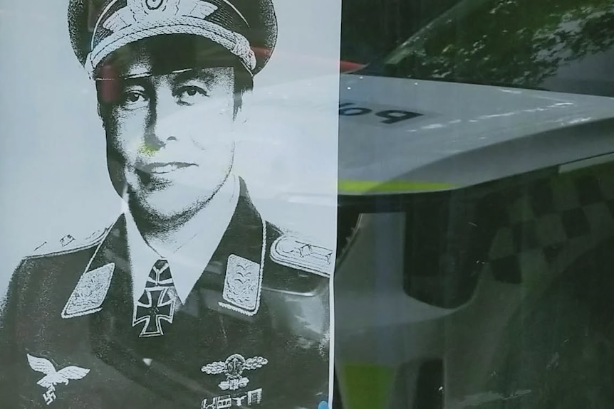 A poster depicting Elon Musk in a Nazi uniform displayed in the window of a Canberra cafe.