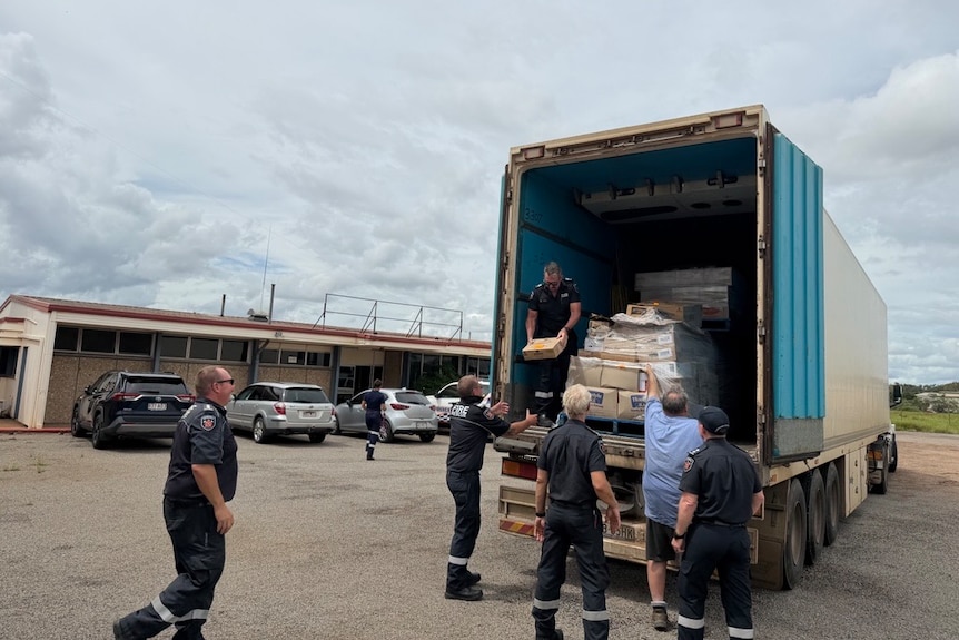 Group of men unloading pallet of boxes from truck