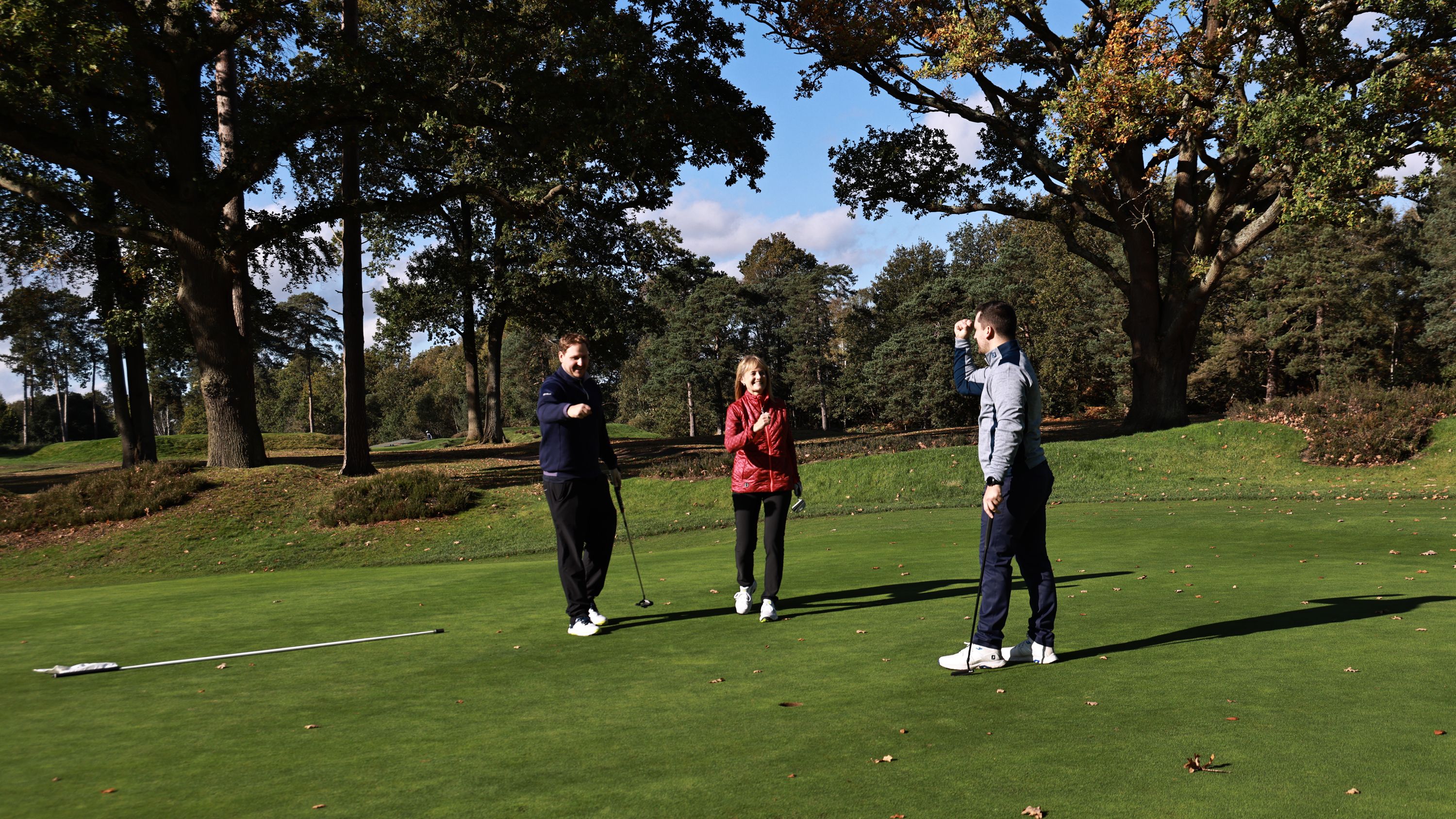 Nick Bonfield, Alison Root and Sam De'Ath celebrating a putt made by Sam De'Ath