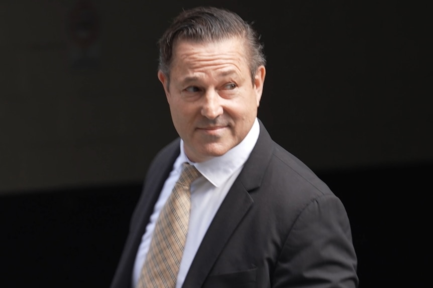 Man in a dark suit with dark background