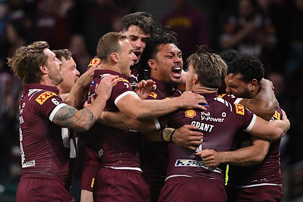 Xavier Coates of the Maroons celebrates scoring a try with teammates.
