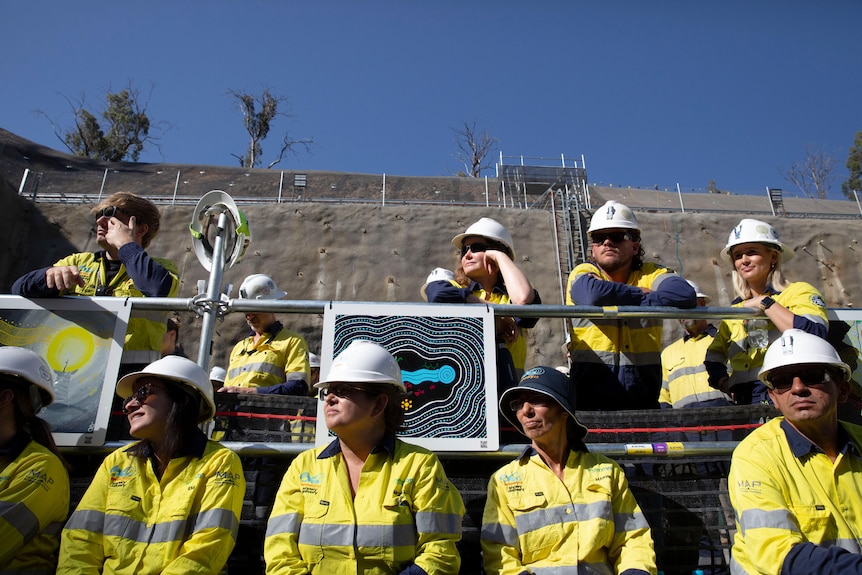 A group of construction workers looking at an event. 