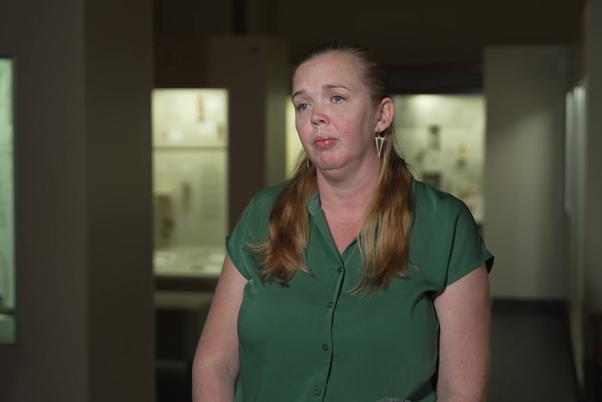 A woman in a green top in a museum
