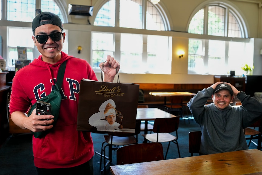 Seafarer Joe smiles and holds a bag of Lindt chocolates