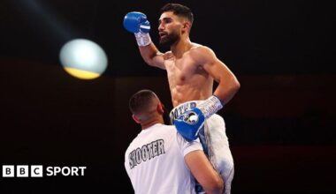 Hassan Ishaq is lifted up by his trainer in celebration