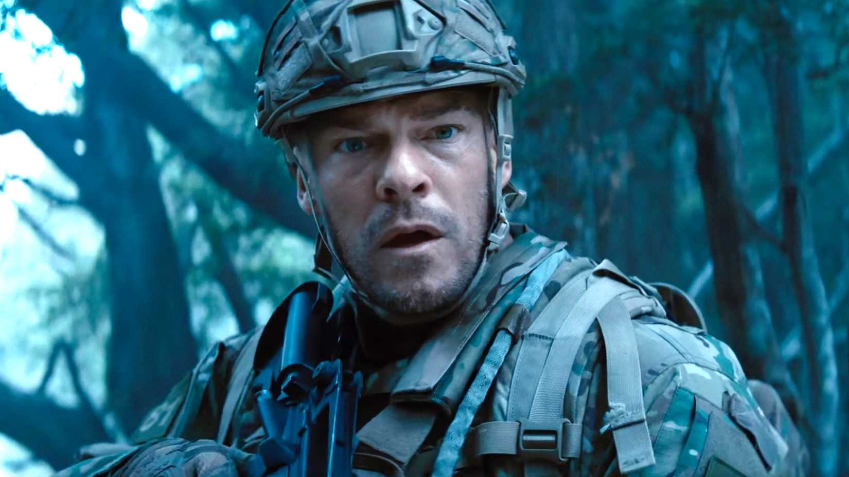 Alan Ritchson looking worried in his army gear in War Machine
