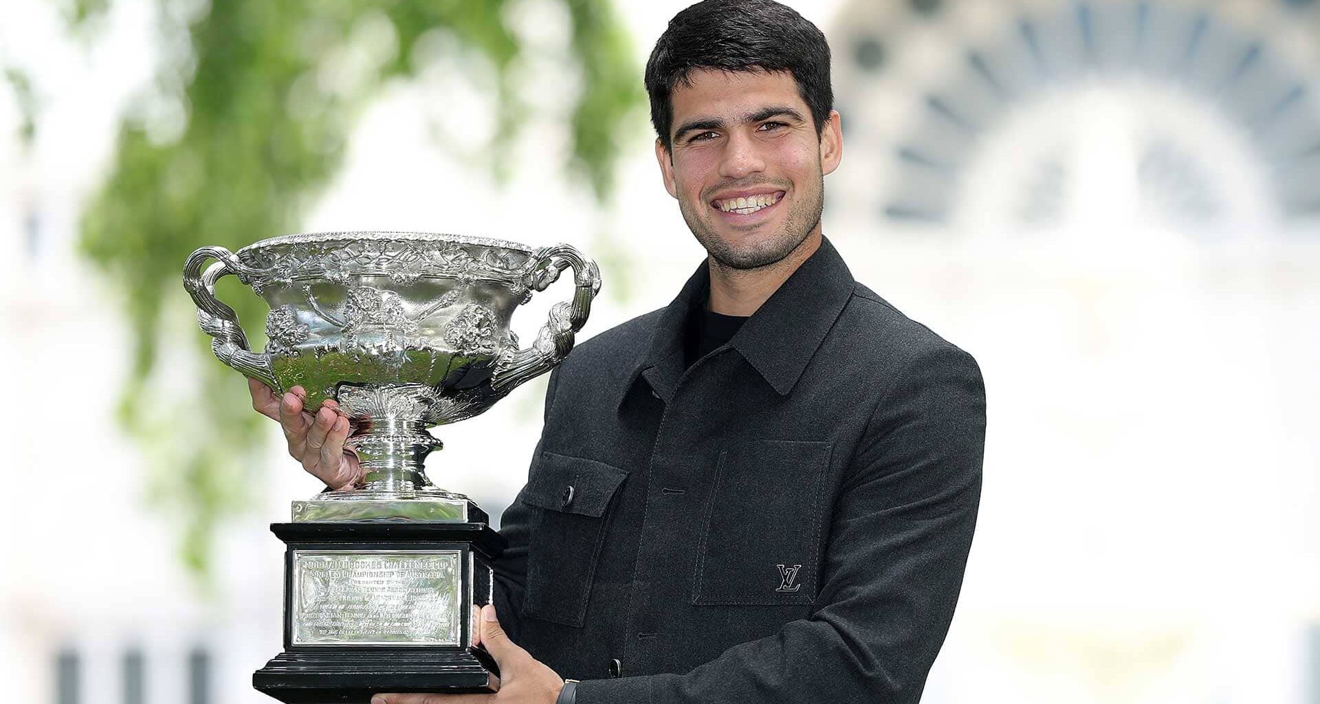 Carlos Alcaraz enjoyed a photoshoot with the Norman Brookes Challenge Cup at the Royal Exhibition Building on Monday.
