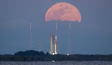 Space Launch System rocket and Orion spacecraft on launcher against rising Moon