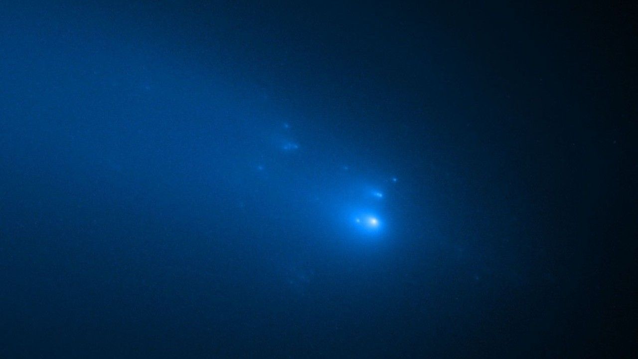bright white and blue dots of light on a black background, with clouds of faint light surrounding them