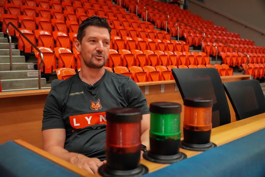 Ryan Petrik sits with stadium seating behind him