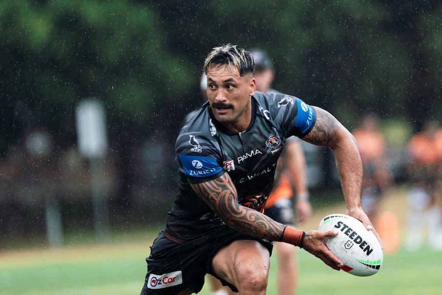A man looks to pass the ball during a rugby league training session 