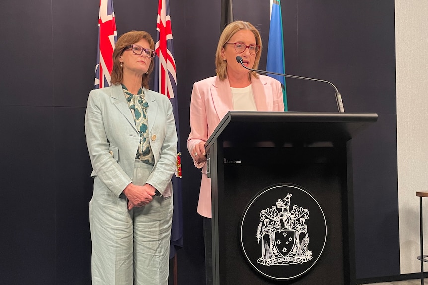 Two women standing at a podium.