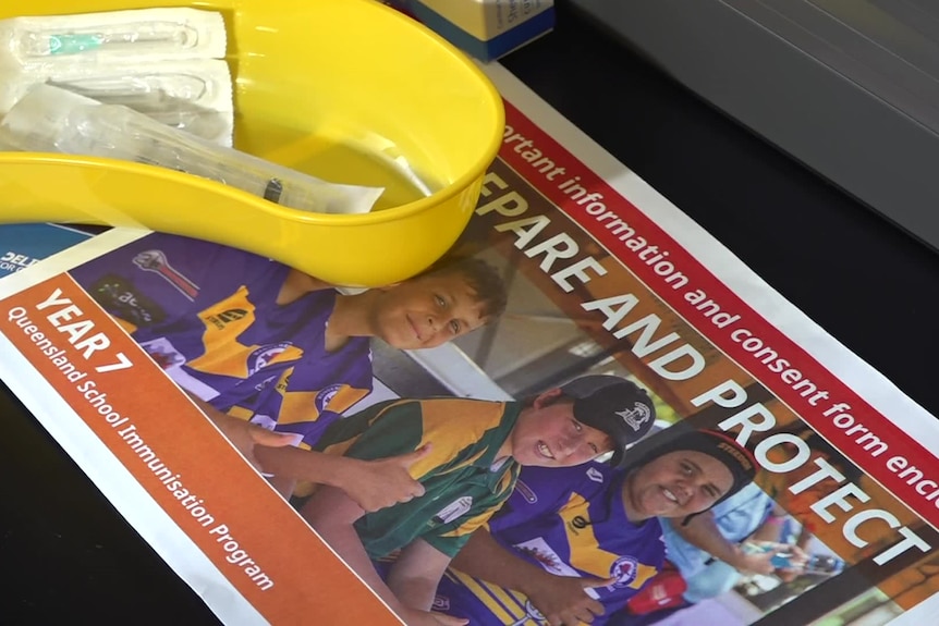 A dish with a needle in it on top of a consent form brochure.