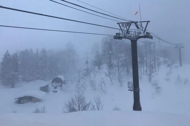 A ski lift on a snowy mountain slope.
