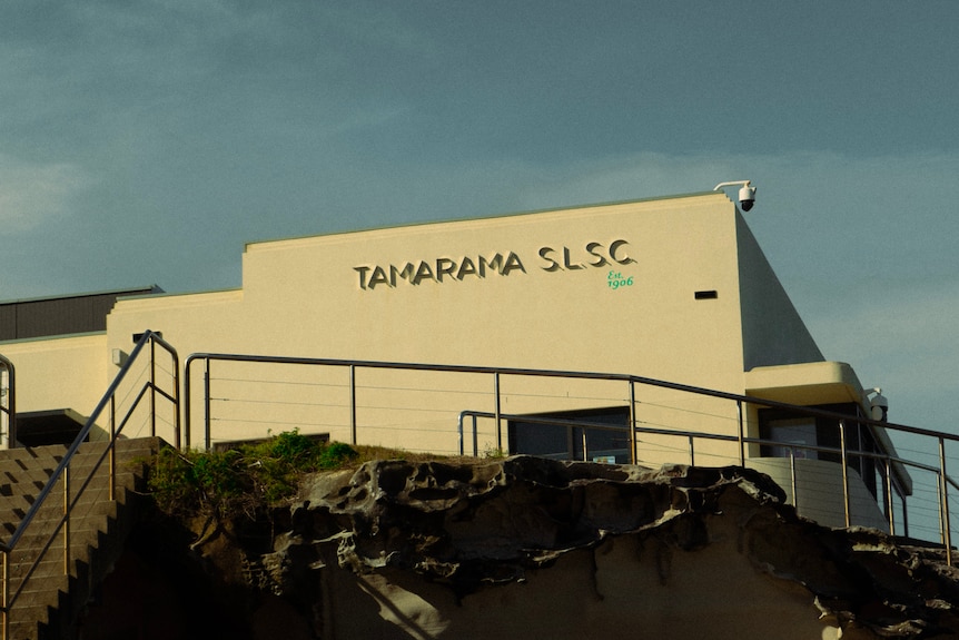 Surf lifesaver building on a cliff with blue sky.