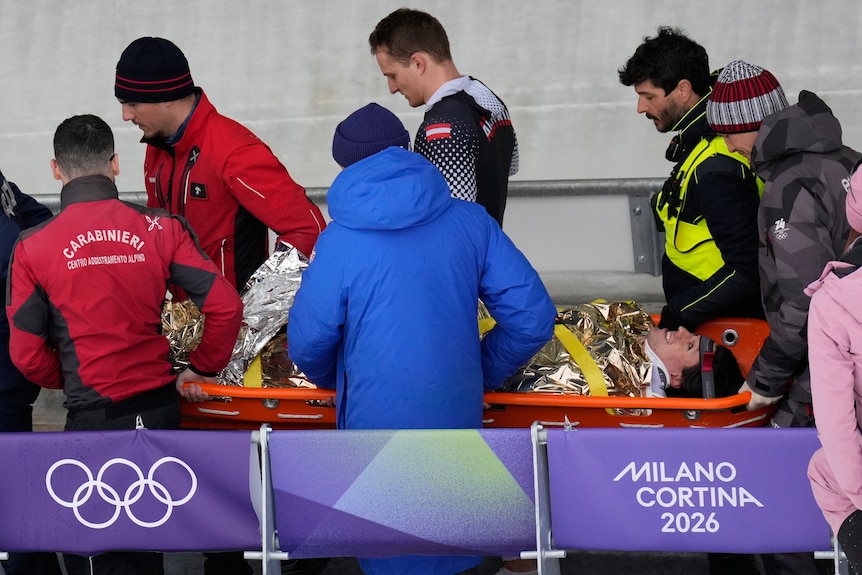 Jakob Manlbauer is taken away on a stretcher after crashing during Olympic bobsleigh event.