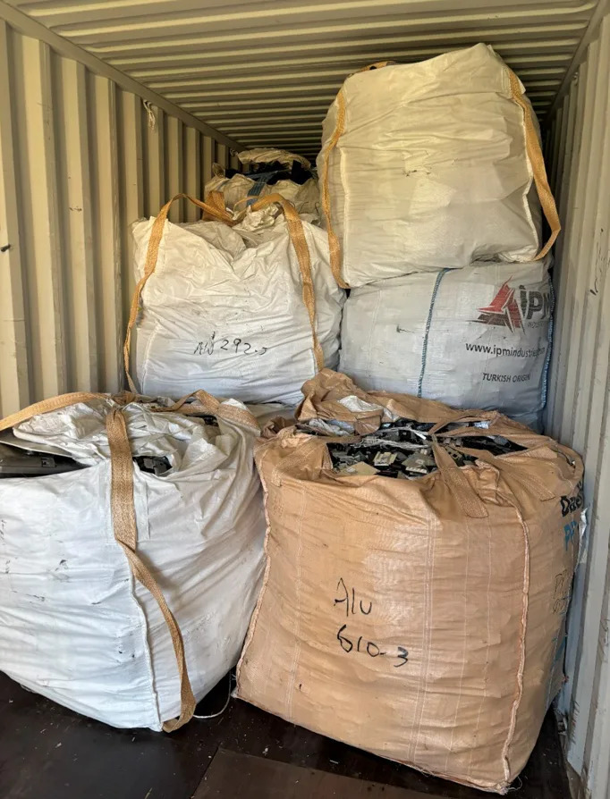 Bags of e-waste piled inside a shipping container.