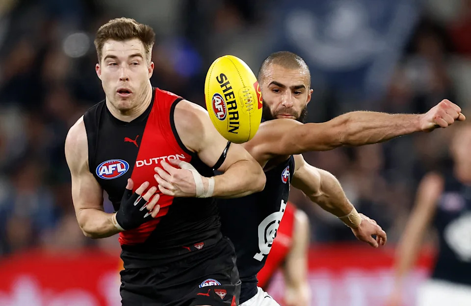 Pictured left is Zach Merrett playing for Essendon.
