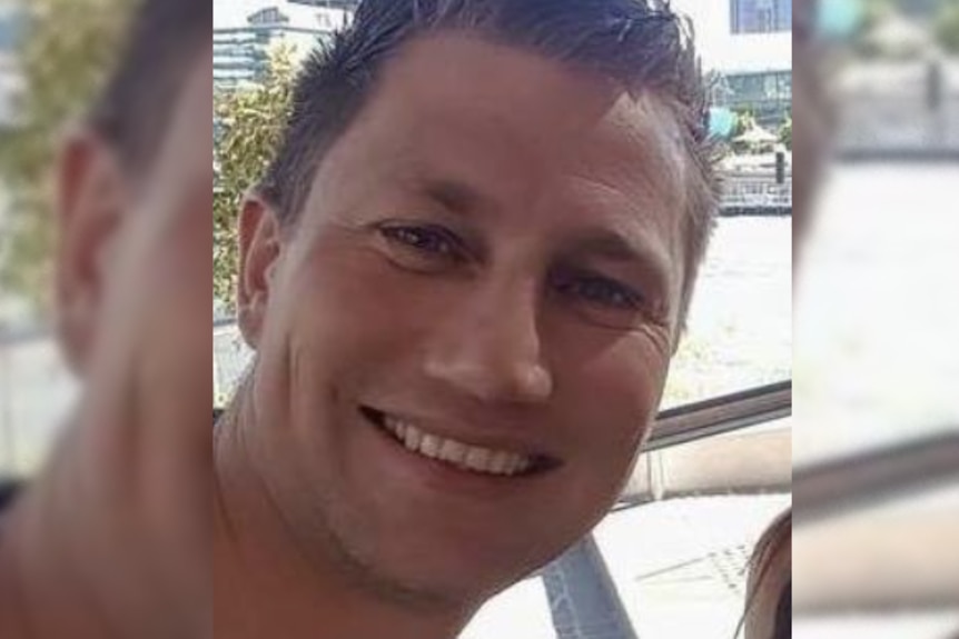 A man with short spiky hair smiles at the camera.