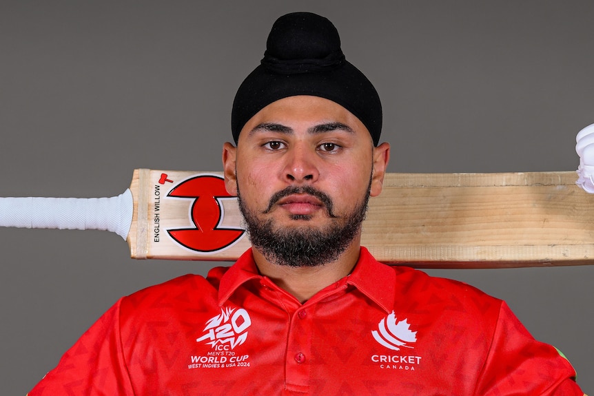 Dilpreet Bajwa holds a bat across his back