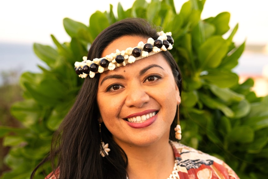 Woman from the Northern Mariana Islands wearing floral top with white woven necklace and traditional shell headband. 