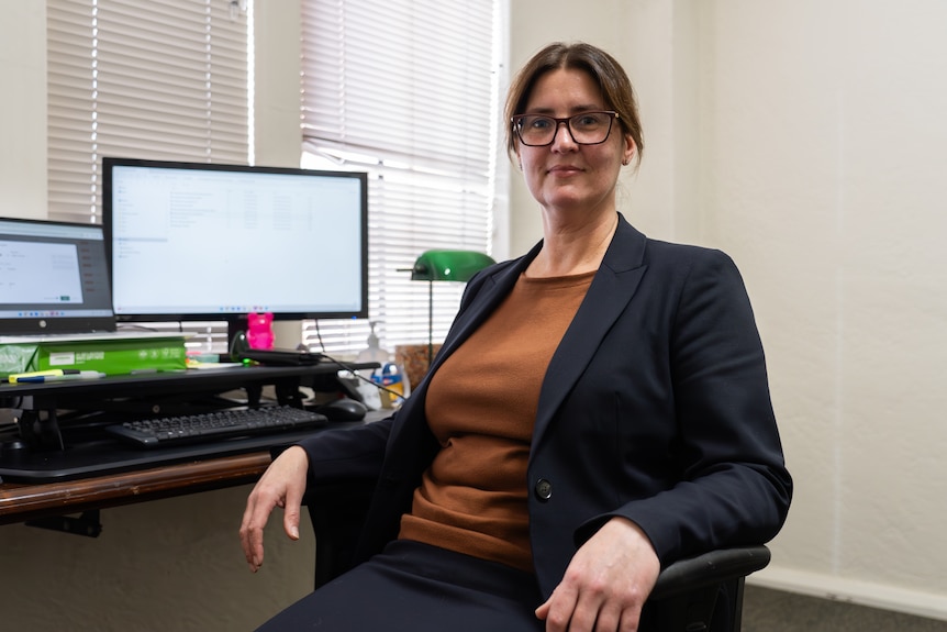 Vanessa Bleyer sits at her desk in an office.