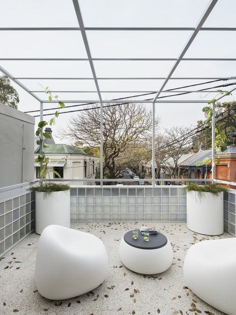 The home actively engages with the city through its open terraces and street-facing volumes.
