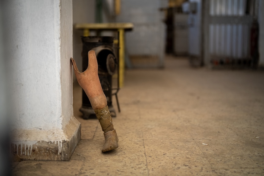 A prosthetic leg leans against a wall in a room.