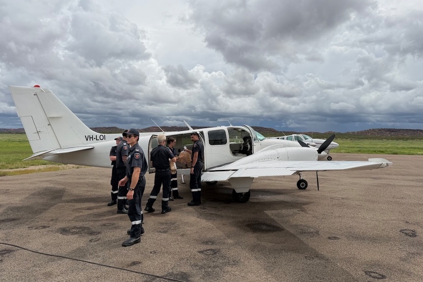 Group of people putting supplies in small plane