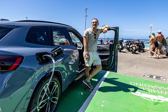 Bondi resident Vincent Rommelaere charges his electric vehicle at the public chargers at the beach.