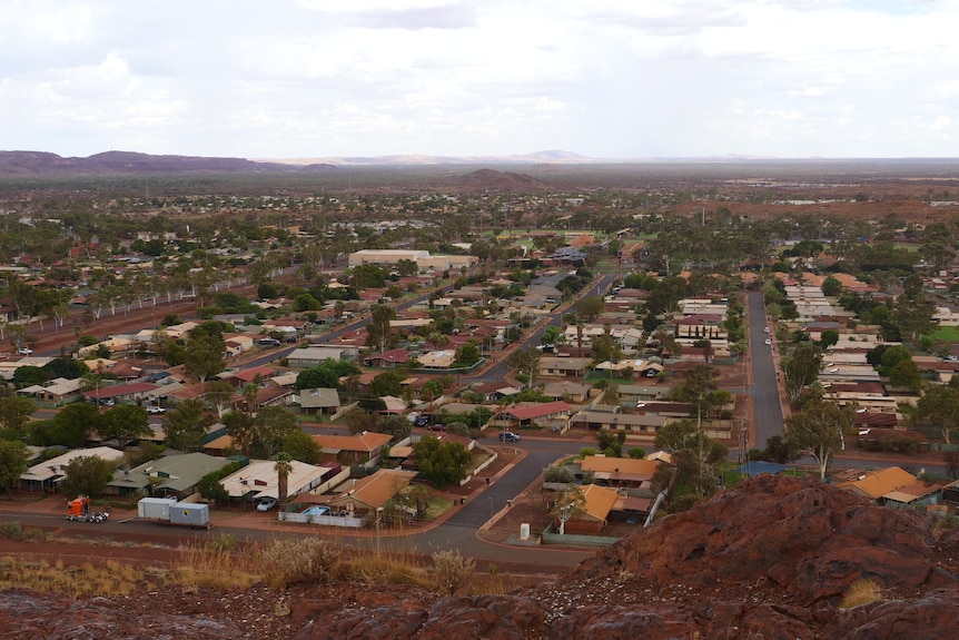 A red dirt town of many houses taken from a high vantage point.