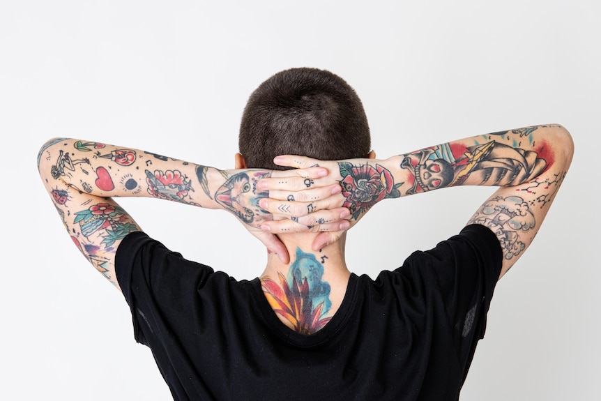 Tattooed person facing away from the camera. 