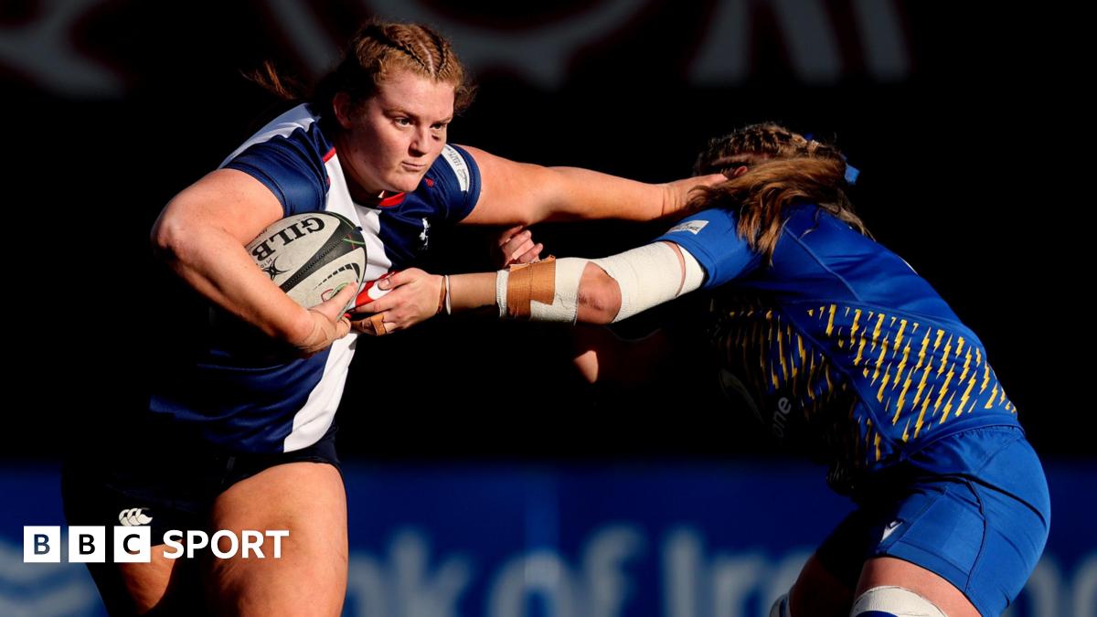 Sophie Barrett of the Wolfhounds hands off an opponent with the ball under one arm