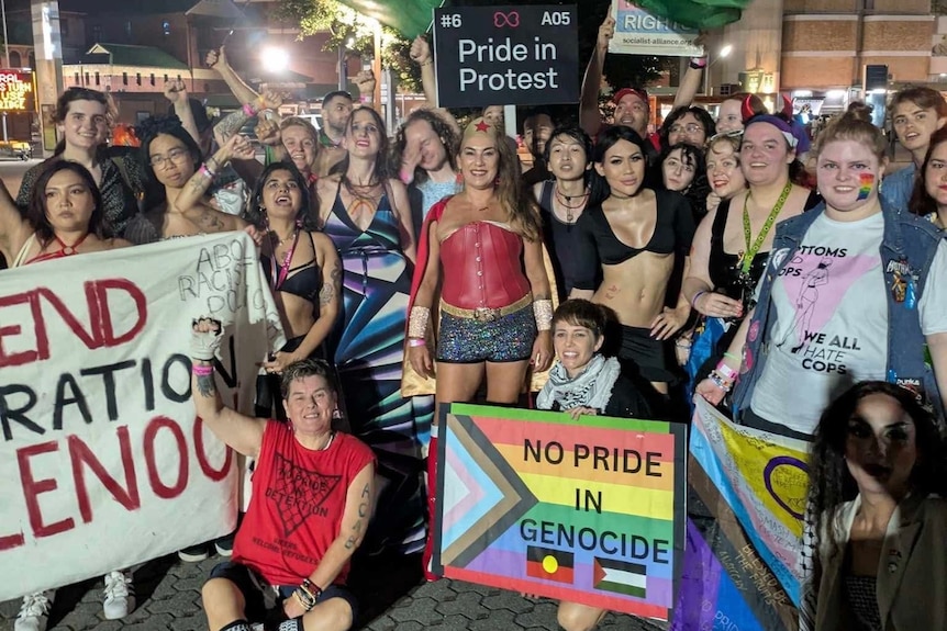 people holiding banners and placards for pride in protest at mardui gras parade
