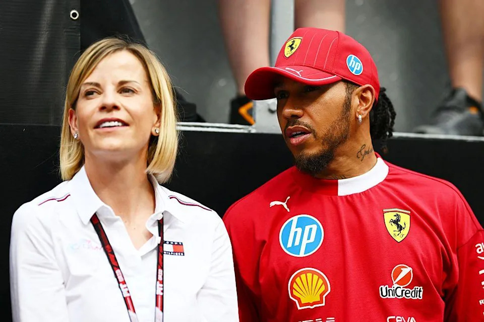 Susie Wolff wears a white shirt whilst Lewis Hamilton is pictured in a red Ferrari cap and race suit.