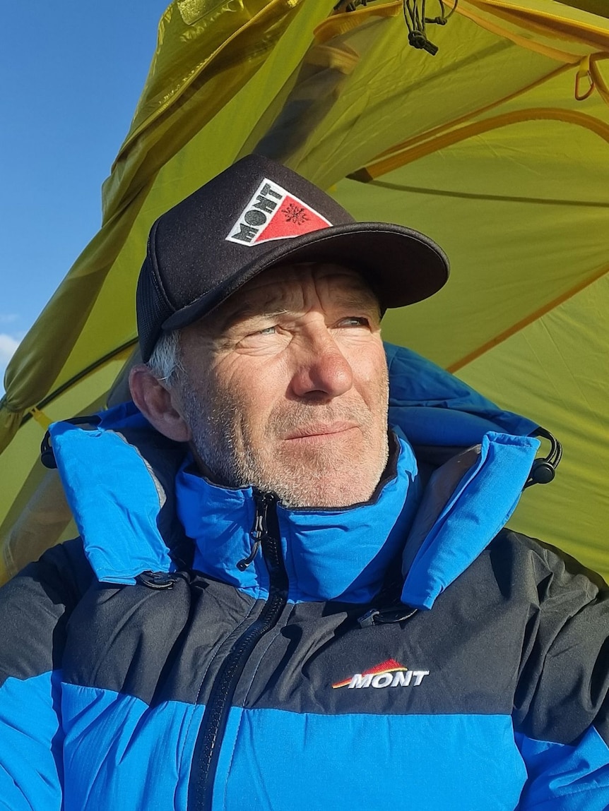 A man in outdoor gear, gazing into the sun.