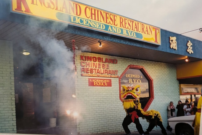A dragon dance is performing in front of a building with the sign "Kingsland Chinese Restaurant"