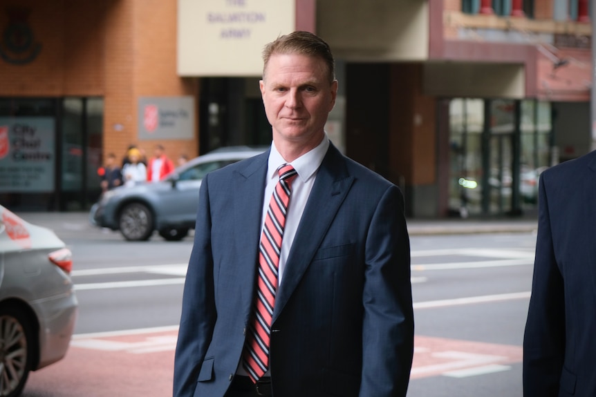 Jonathan Beard arrives at court wearing a suit and tie.