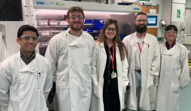 Academic with PhD students in a chemistry lab