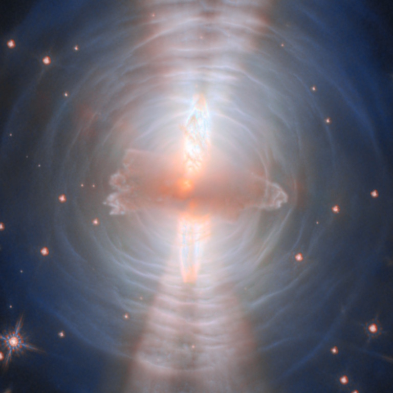 An image of the protoplanetary nebula known as the Egg Nebula, captured by Hubble, showing a dying sun-like star at its center with layered gas clouds and illuminated dust in space.