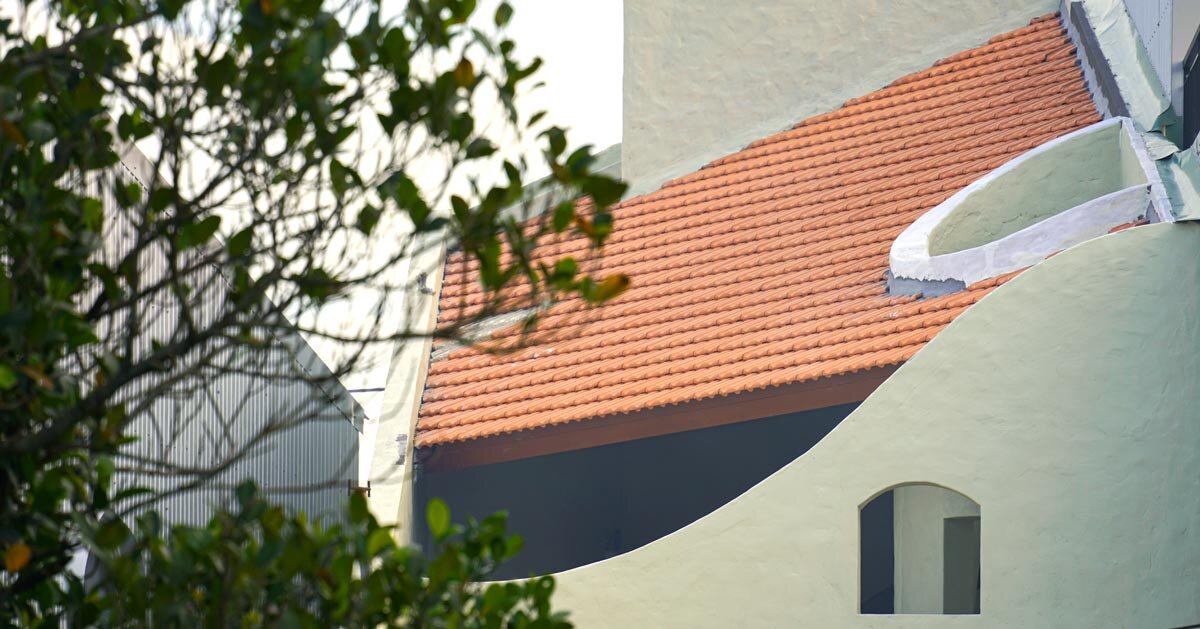 curved cutouts sculpt fluid voids within gabled residence in vietnam