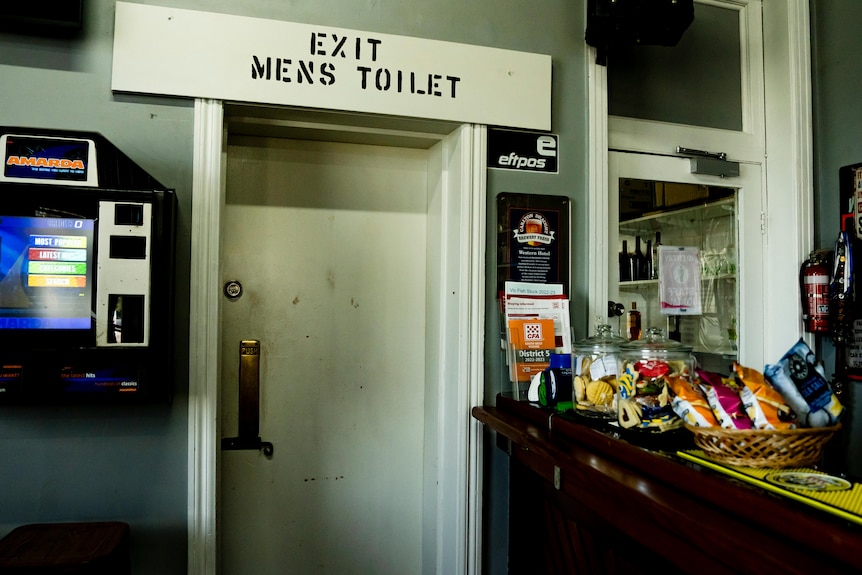 A pub with a door that says Exit Men's Toilets above it.